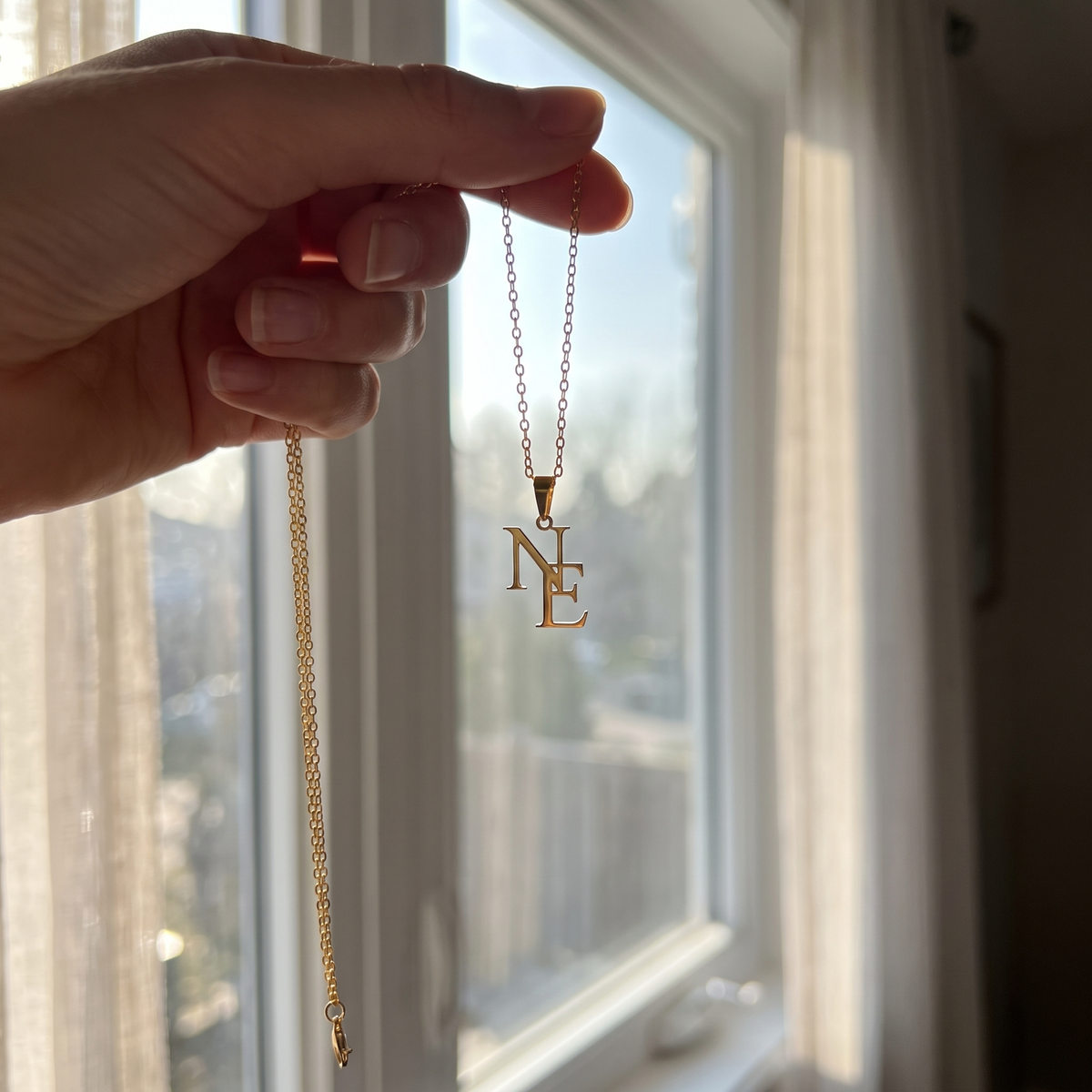 LUVED initials necklace held up