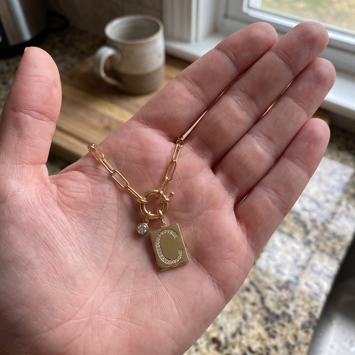 PAVE initial necklace in hand